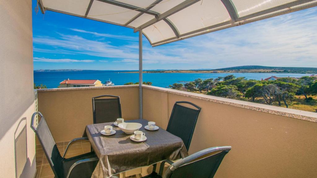 un tavolo e sedie su un balcone con vista sull'oceano di Apartments Stef in Kosljun island Pag a Košljun