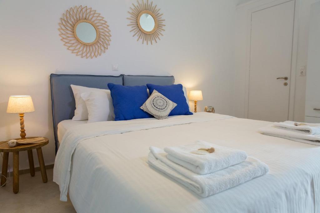 Un dormitorio con una cama azul y blanca con toallas. en Bay View Villas en Methoni