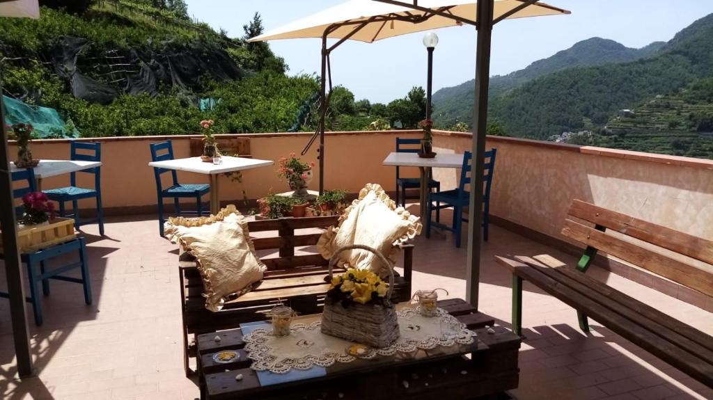 a patio with tables and chairs and an umbrella at Hotel affittacamere novella in Tramonti