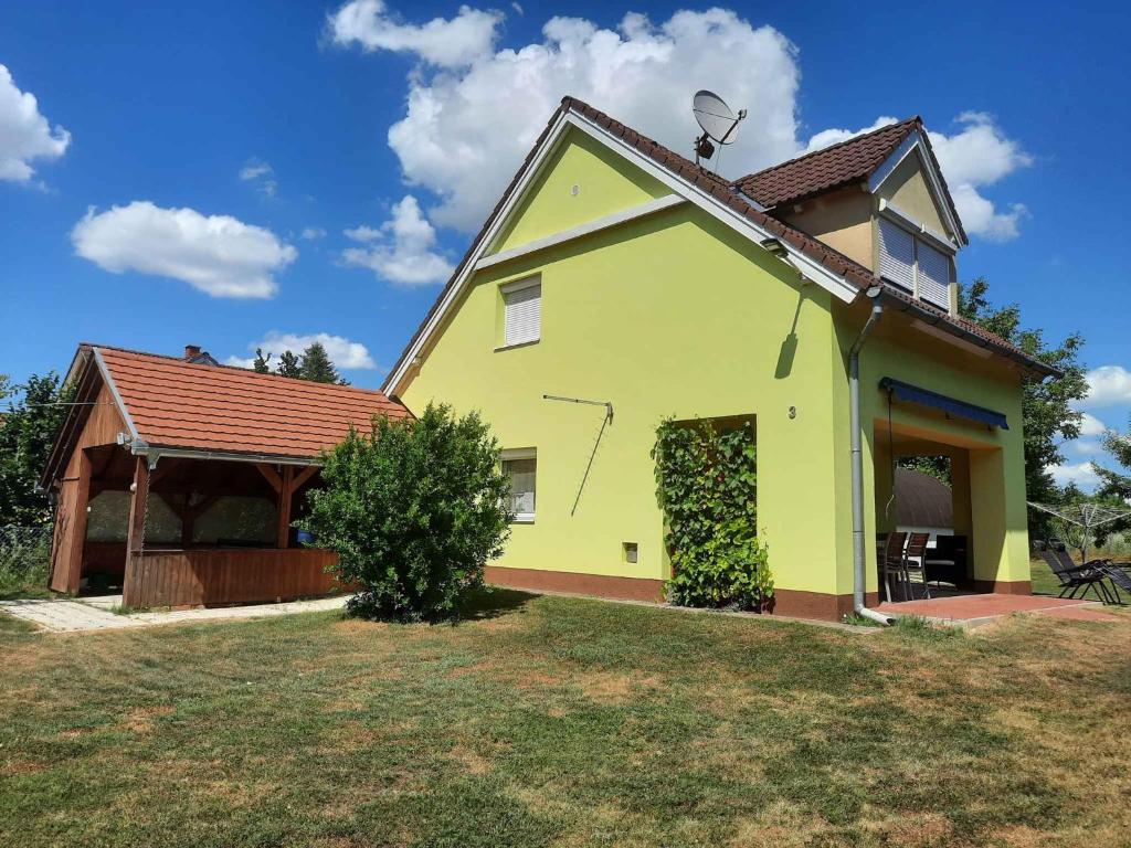 バラトンベレーニにあるHoliday home in Balatonbereny 34653の庭の見晴台付黄色い家