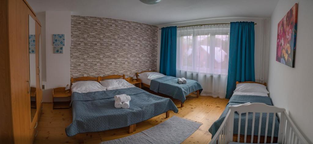 a bedroom with two beds and a window at Apartmány 105 in Habovka