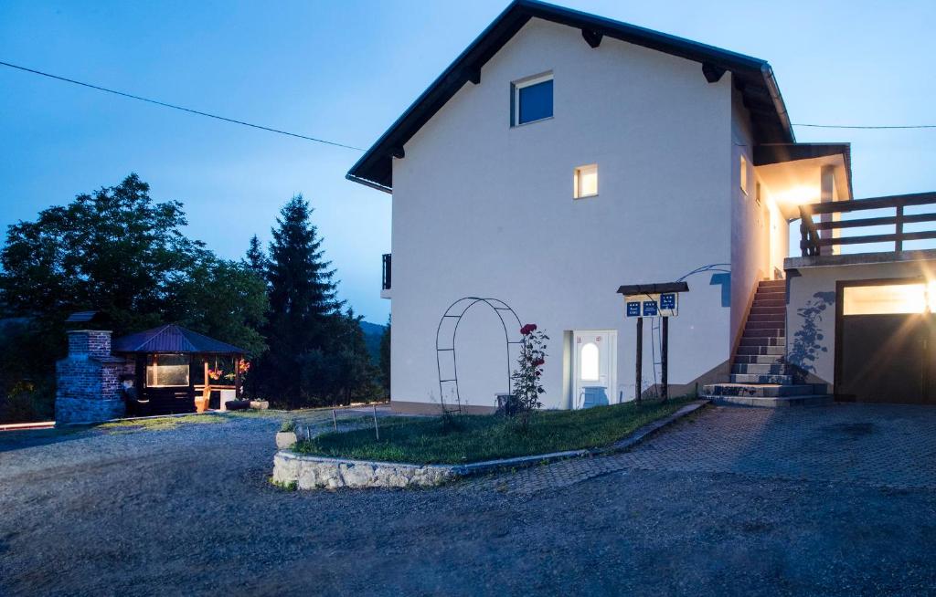 a white house with a gate and a driveway at Apartments Vesna in Slunj