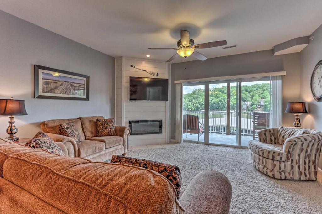 a living room with a couch and chairs and a fireplace at Idyllic Camdenton Condo with Community Pool and Lake! in Camdenton