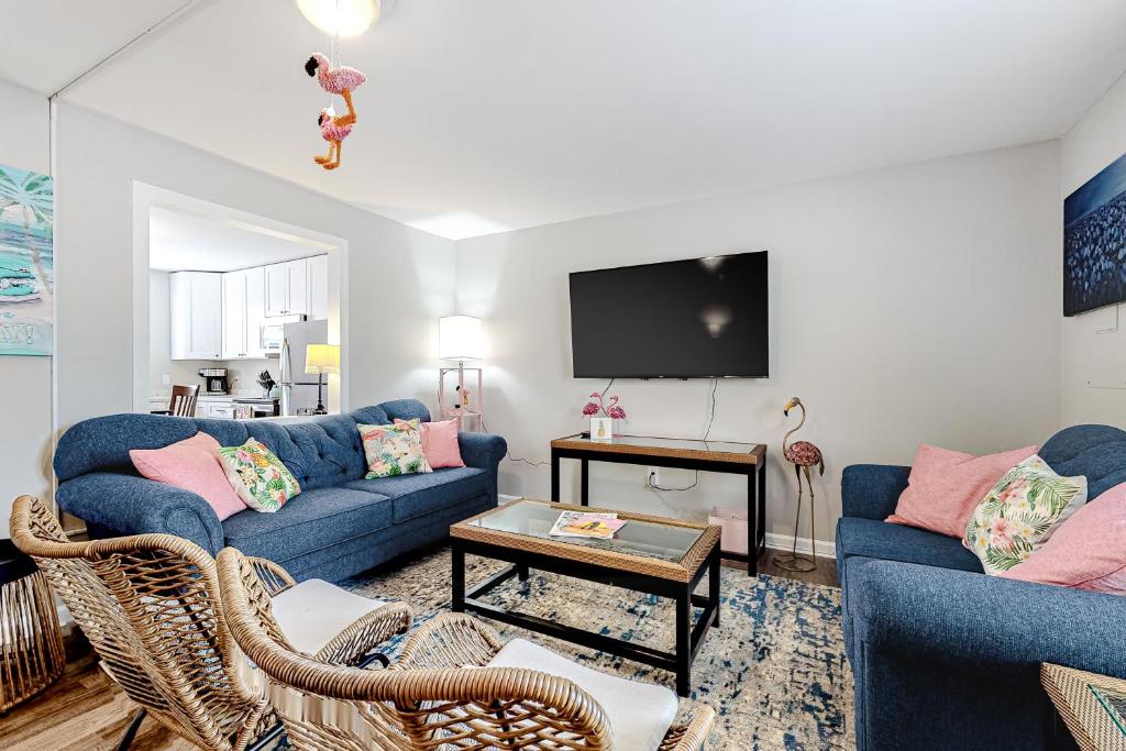 大洋城的住宿－The Flamingo House，客厅配有2张蓝色沙发和电视