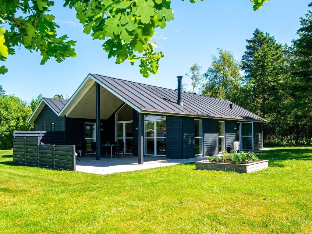 ein grünes Haus mit einem Gameradach in der Unterkunft 6 person holiday home in L gst r in Løgsted