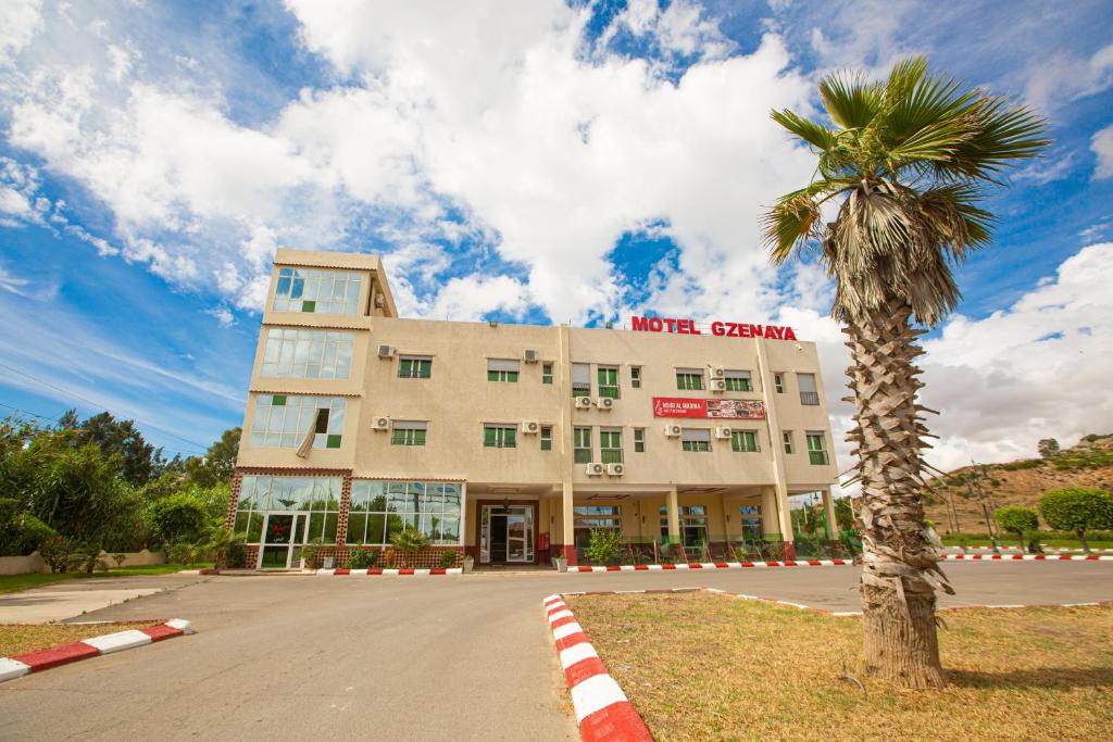 een palmboom voor een gebouw bij Motel Gzenaya in Tanger