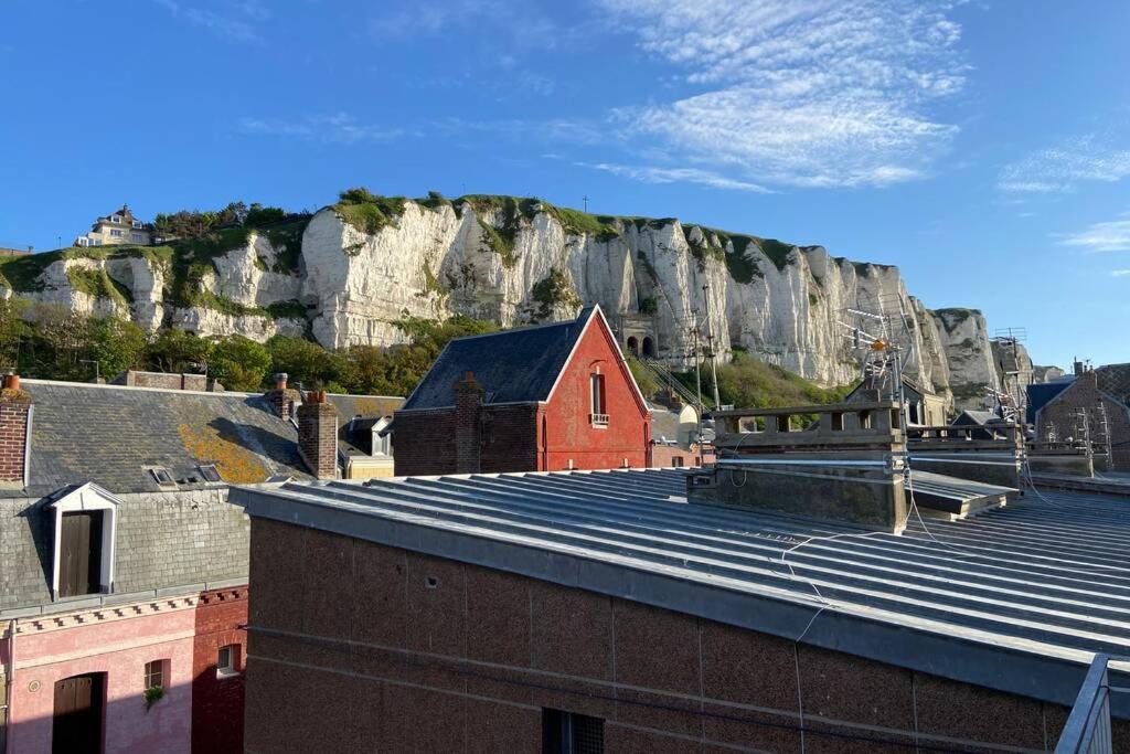 a view of a red building with a mountain in the background at Détente en plein coeur du Tréport ! in Le Tréport