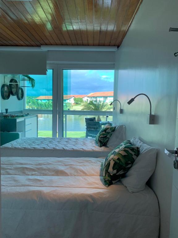a bedroom with a large bed and a large window at Flat Fabuloso 808 Villa Hípica in Gravatá