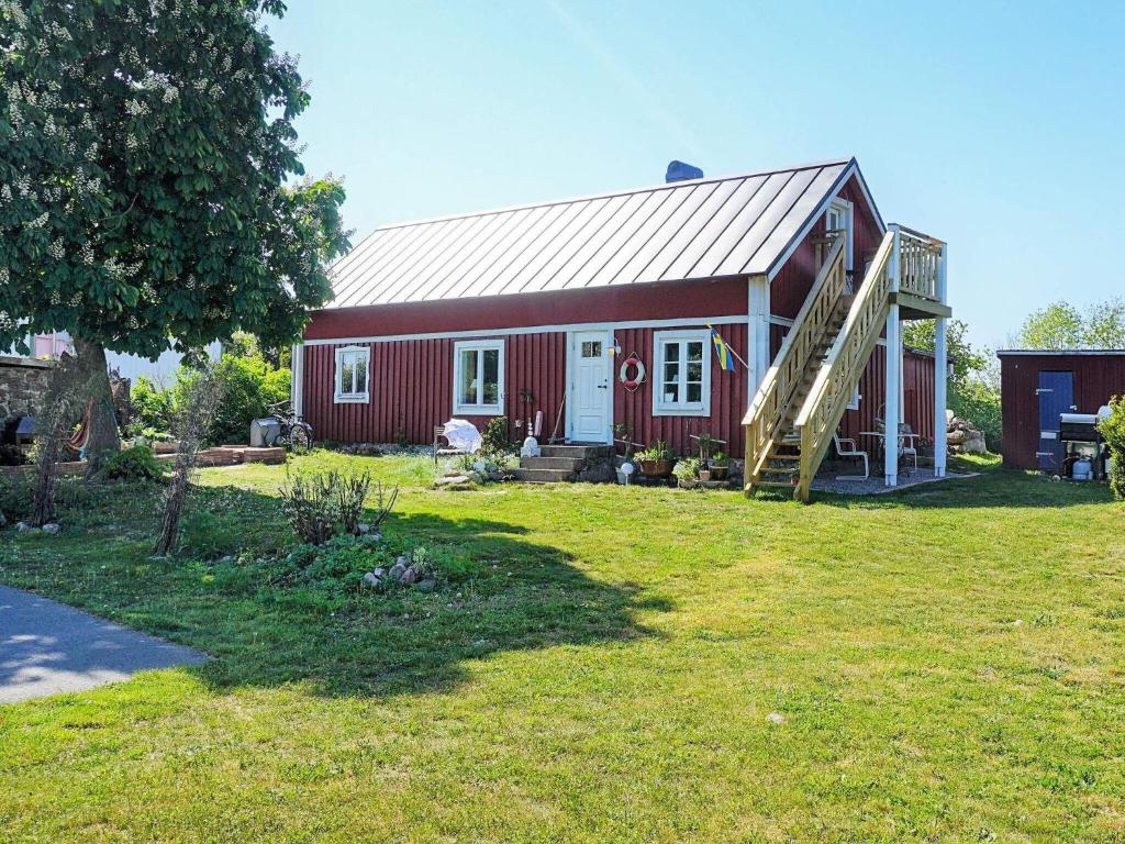 um celeiro vermelho com um alpendre num quintal em 6 person holiday home in S LVESBORG em Sölvesborg