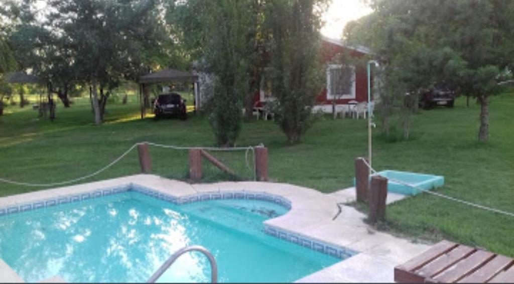 a swimming pool in a yard next to a house at Cabañas Los Girasoles in Gualeguaychú