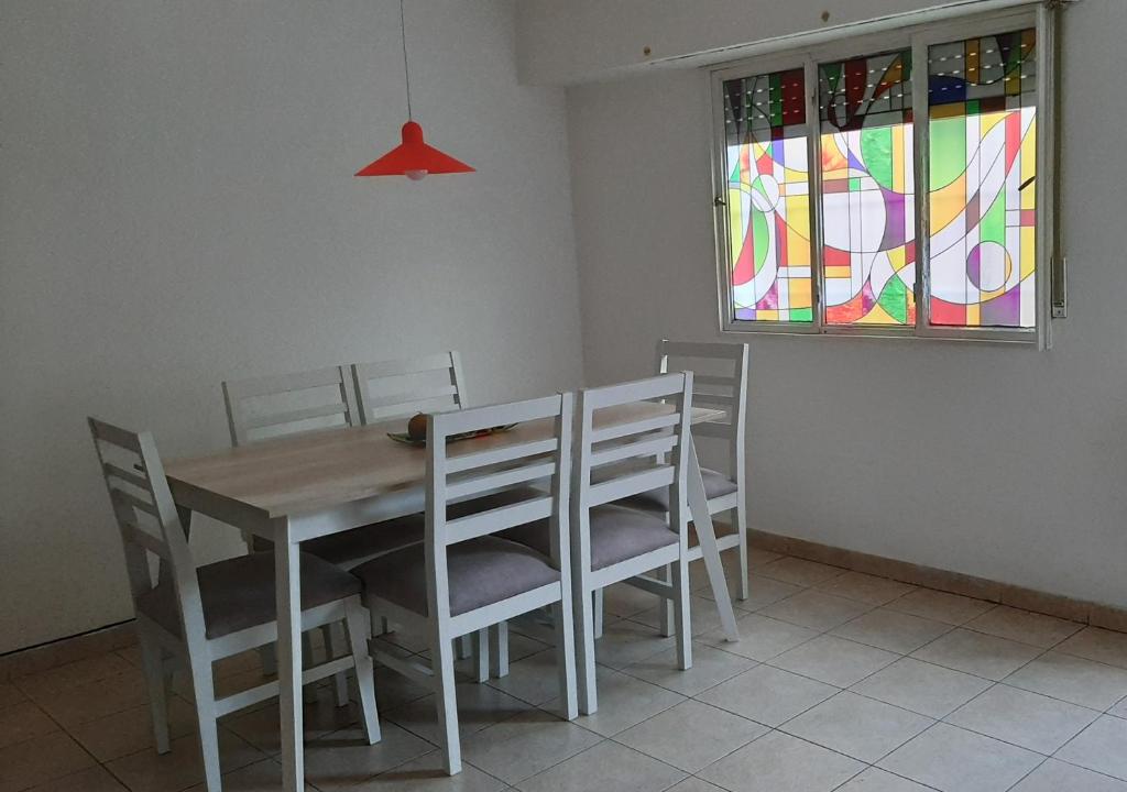 a dining room with a table and chairs and a stained glass window at Q255 - Dpto PB zona residencial en Neuquen in Neuquén