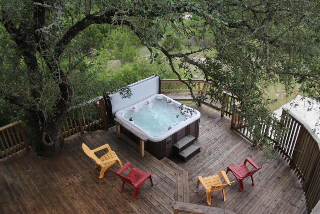 a hot tub sitting on a wooden deck with chairs at Villa at Canyon Lake CL 1233 in Canyon Lake