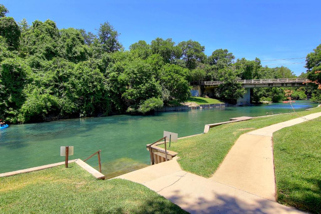 a river with a bridge in the background at Ripley River Haus IC 302 in New Braunfels