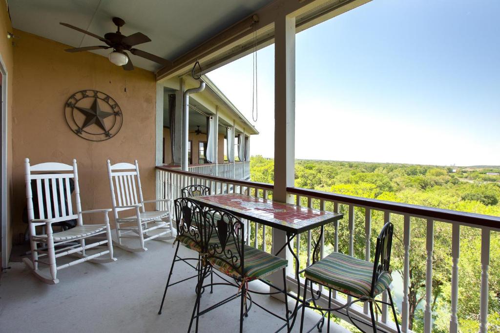 balcón con sillas, mesa y ventana en Rio Hacienda VG 306, en New Braunfels