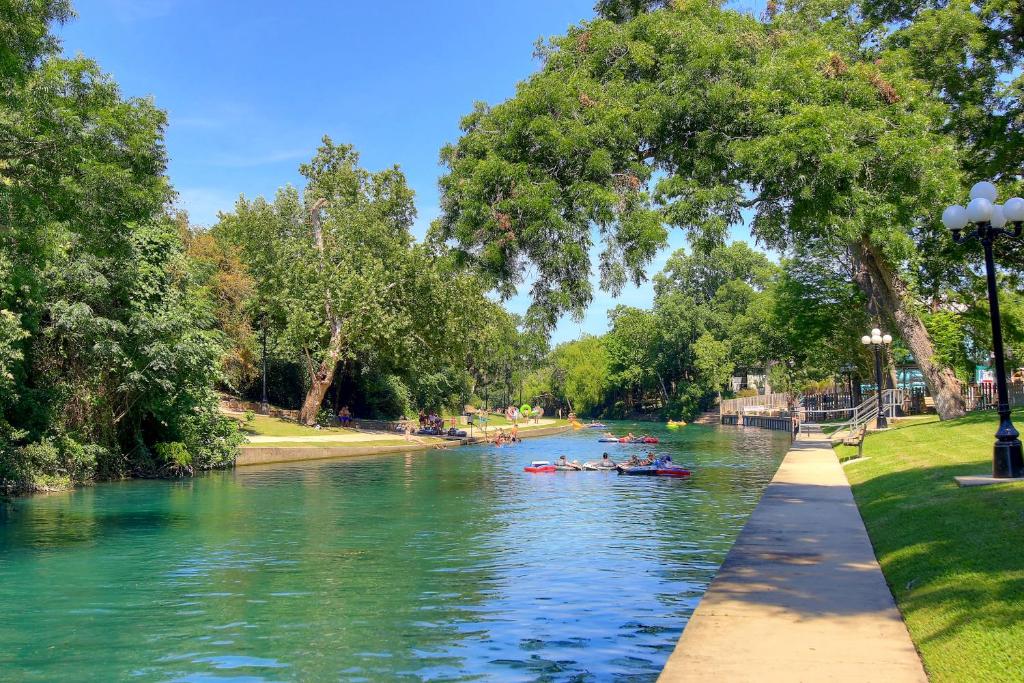 people kayaking down a river in a park at Riverpalooza RRC A305 in New Braunfels