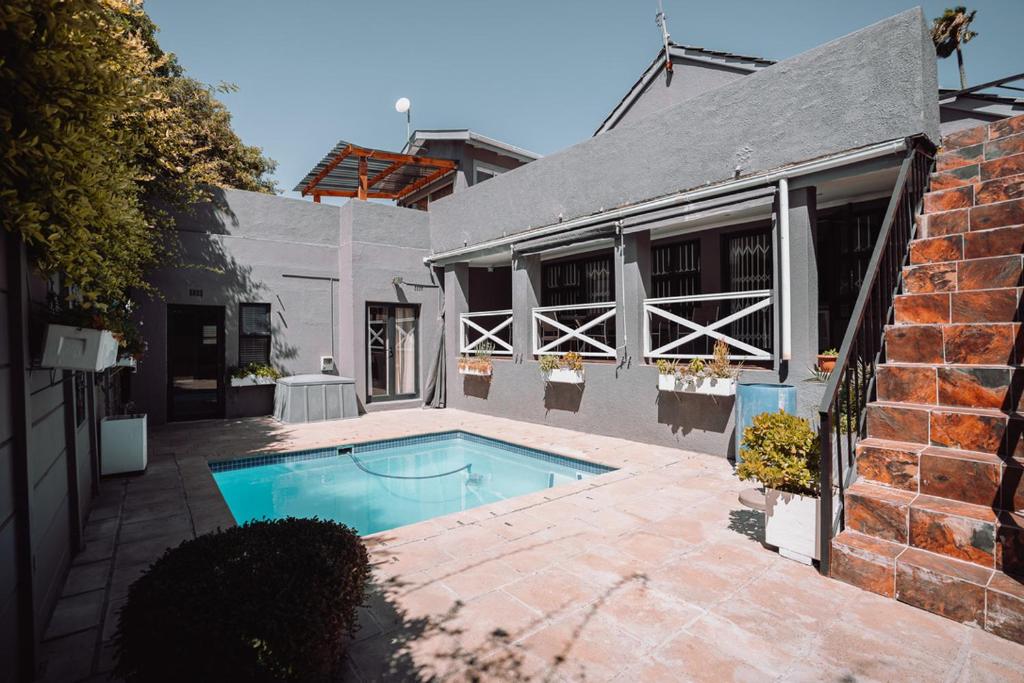 een zwembad in de achtertuin van een huis bij Rondebosch Luxury Living in Kaapstad