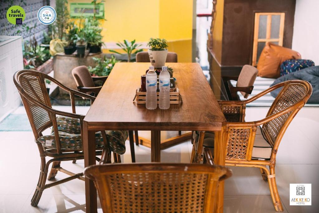 een houten tafel met stoelen en een eetkamer bij Aekkeko hostel in Phuket