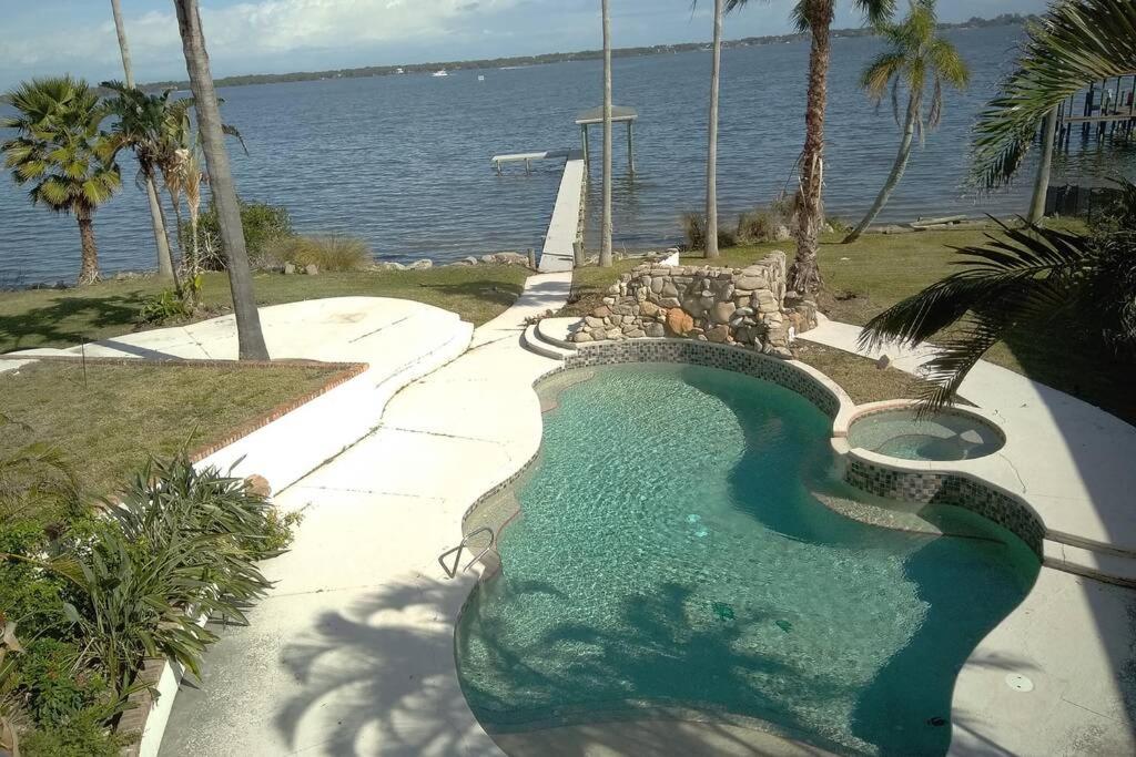 einem Pool neben einem Wasserkörper in der Unterkunft Pineda Palms Estate, 4 BR for 13 guests in Melbourne