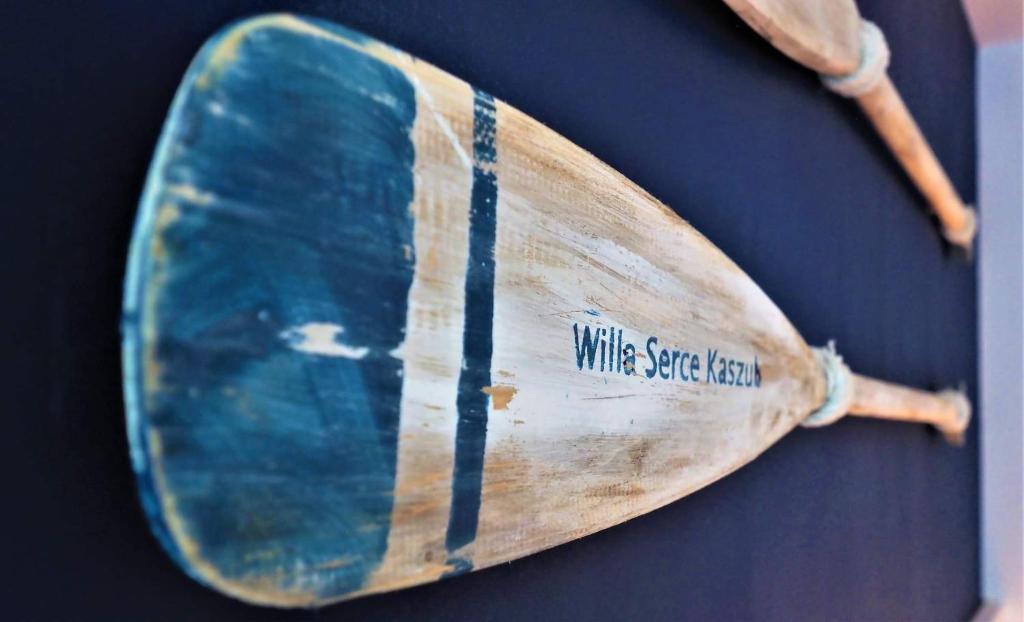 een houten surfplank met de woorden wijnruimte naar het oosten erop bij Serce Kaszub. Pokoje z niezależnym wejściem. in Swarzewo