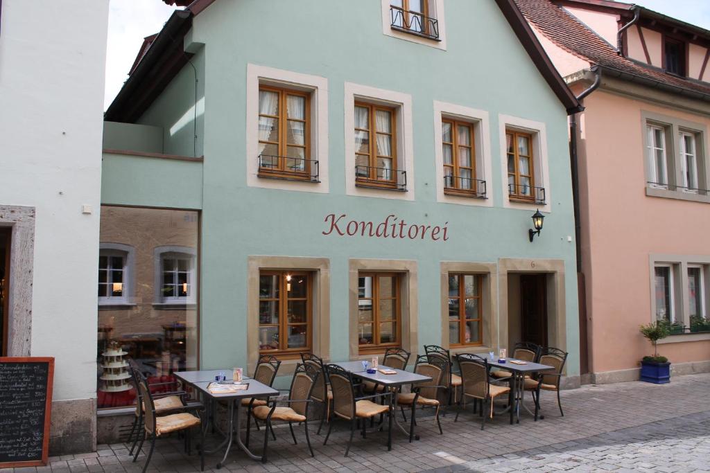 ein Restaurant mit Tischen und Stühlen vor einem Gebäude in der Unterkunft Hotel Uhl in Rothenburg ob der Tauber