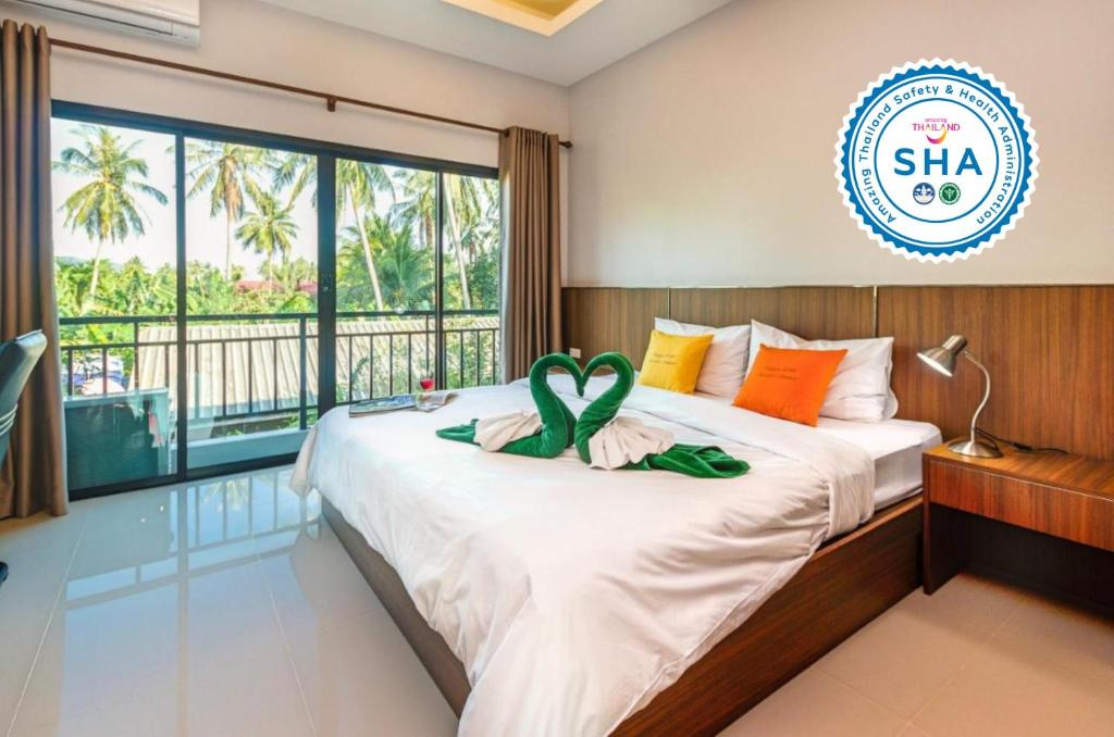 a bedroom with a bed with a sign that reads sla at Happy Eight Resort SHA in Nai Harn Beach
