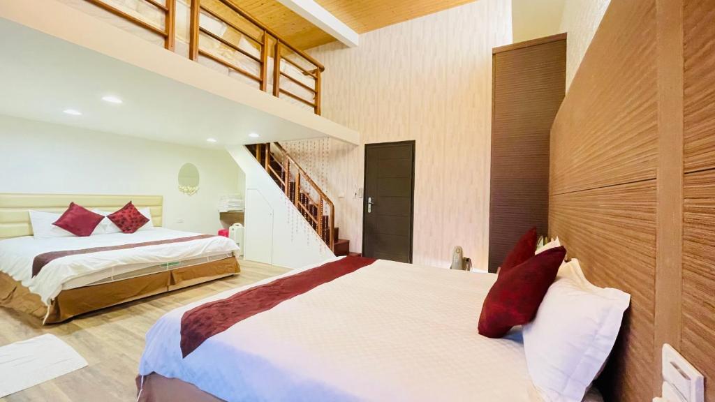 a bedroom with two beds and a staircase at Jabez B&B in Jiaoxi