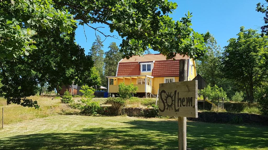 a sign in front of a house with a house at Solhem in Älmeboda