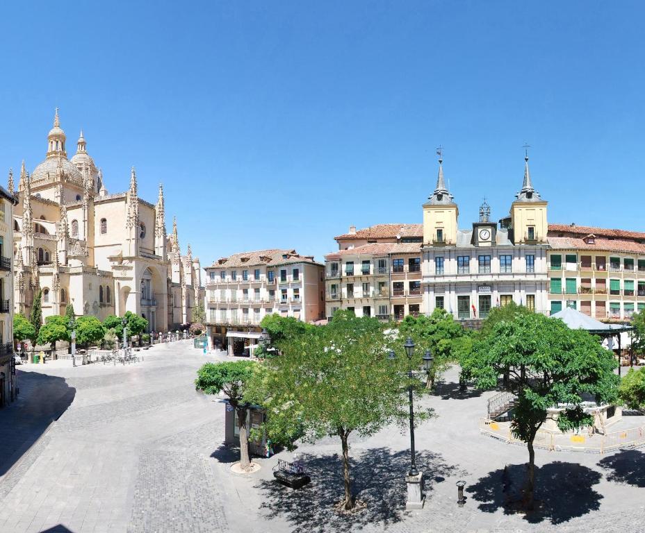 
a large building with a clock on the top of it at Infanta Isabel by Recordis Hotels in Segovia
