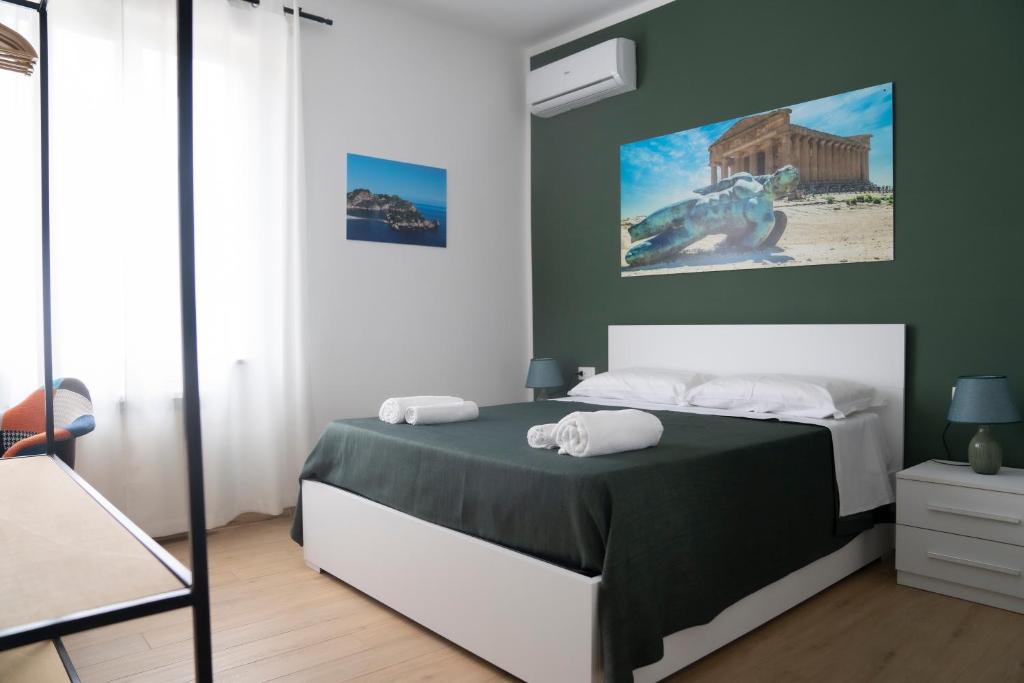 sypialnia z łóżkiem i zieloną ścianą w obiekcie B&B Socrate w mieście Agrigento