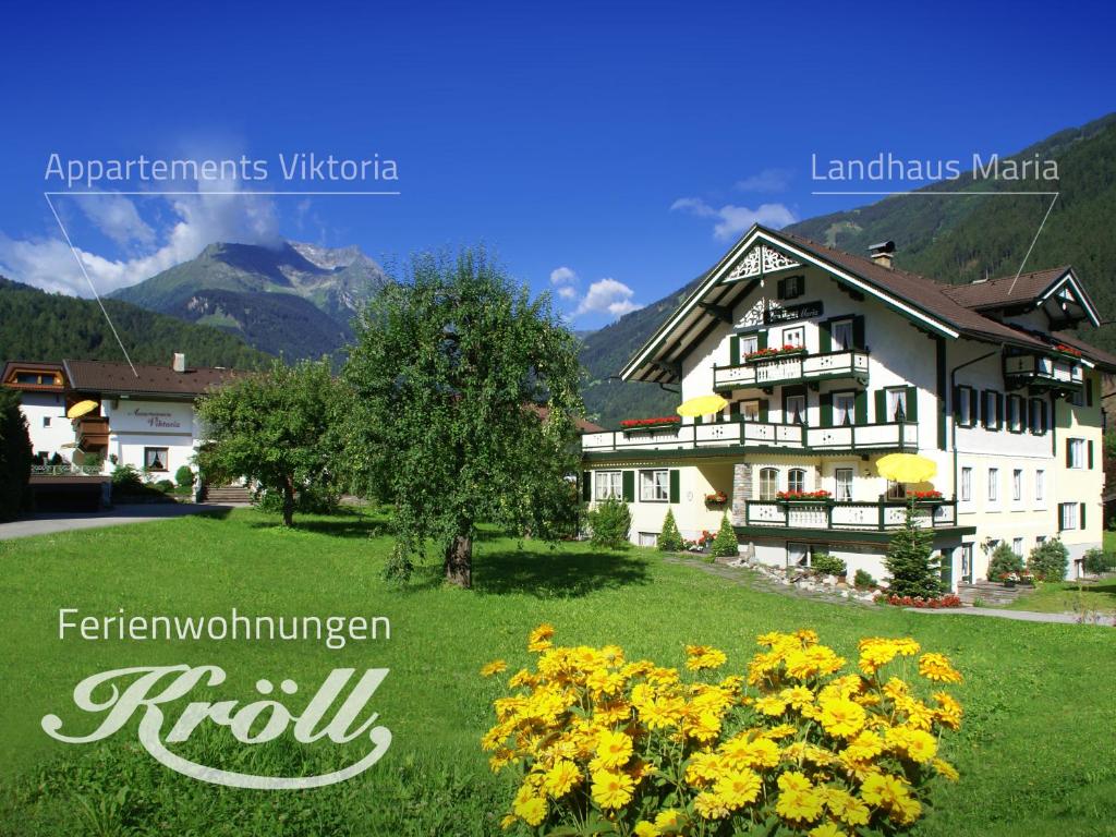 un hotel en las montañas con flores amarillas en primer plano en Ferienwohnungen Kröll - Appartements Viktoria und Landhaus Maria, en Mayrhofen