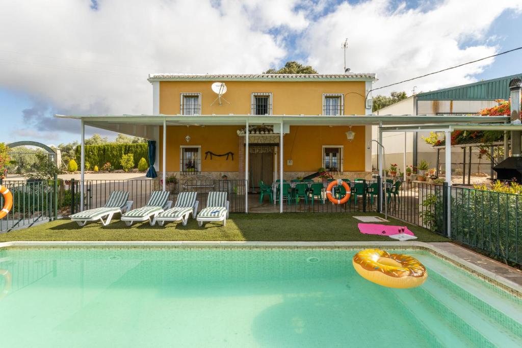 uma casa com piscina em frente a uma casa em Cortijo Rural Puerto Nuevo em Málaga