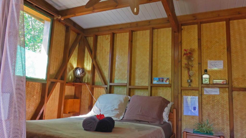 Dumbéaにあるla Cabane de la Valleeの木製の壁のベッドルーム1室(ベッド1台付)