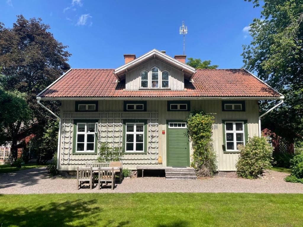 una casa verde y blanca con una puerta verde en Äppelgården, en Mariestad