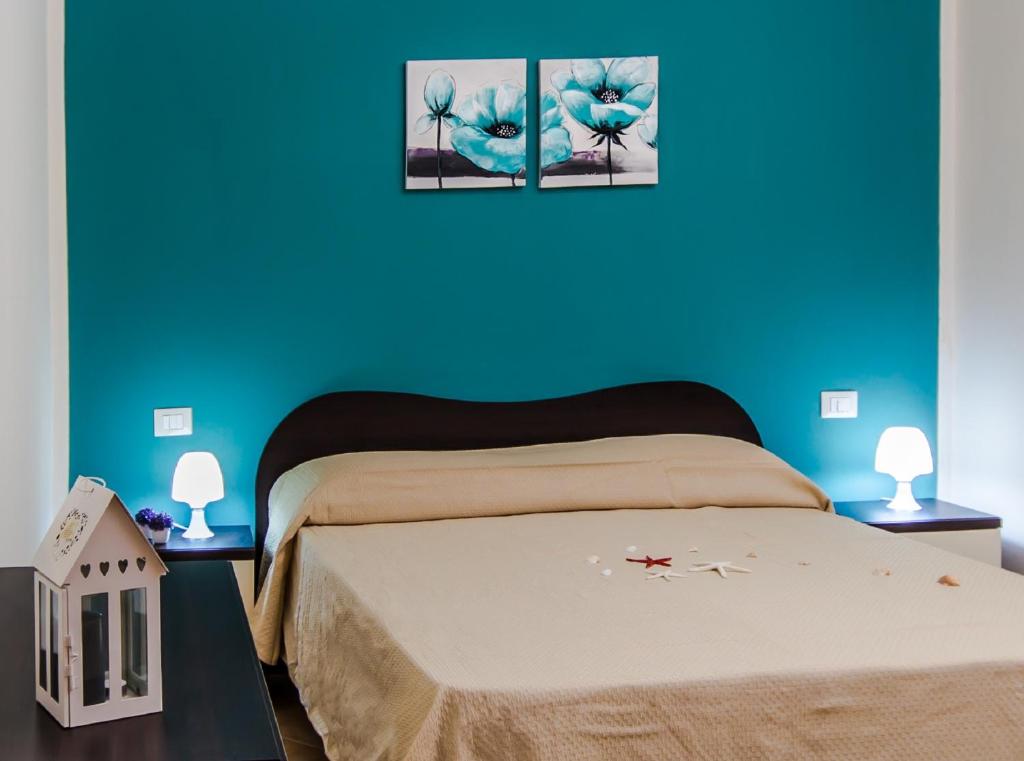 1 dormitorio con 1 cama con 2 cuadros en la pared en Casa vacanze Biondo, en Trappeto