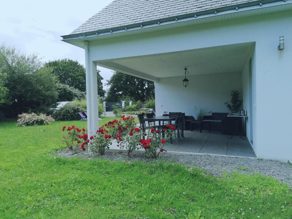 un pabellón blanco con mesa, sillas y flores en Chambres d'hotes Grace, en Guérande