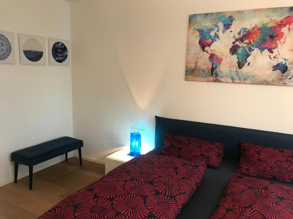 a bedroom with a bed with a red comforter and a table at Casa sciliar blu centro paese in Völs am Schlern