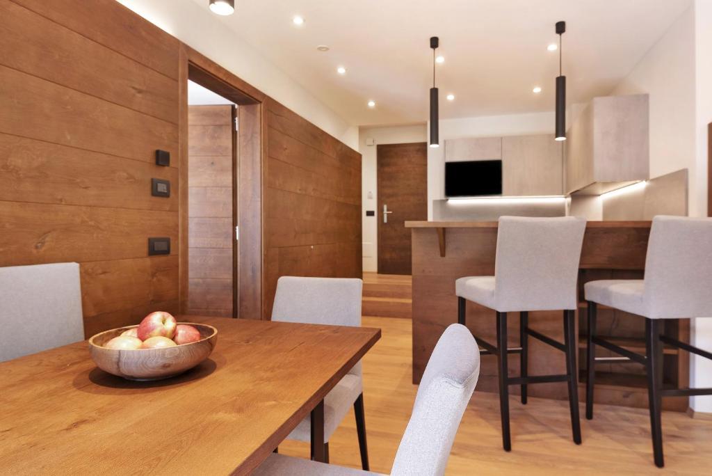 a kitchen and dining room with a wooden table and chairs at Apartments Montblanc Sella in Ortisei