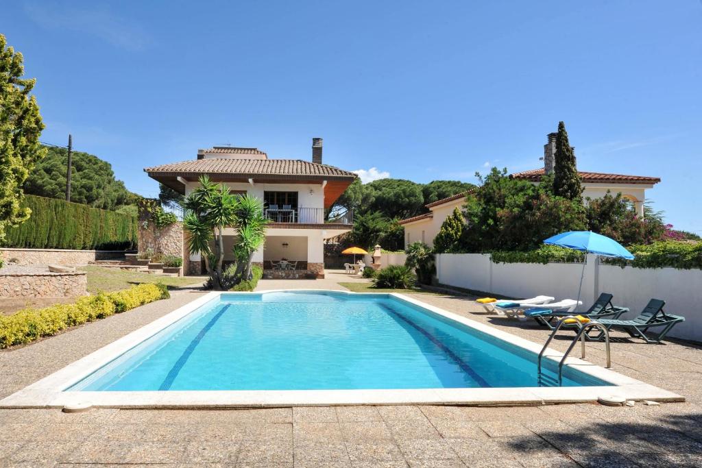 a swimming pool in front of a house at Ramon in L'Escala