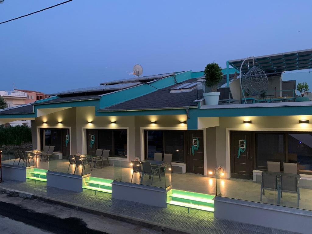 ein Gebäude mit einer Terrasse mit Tischen und Stühlen in der Unterkunft STREET 90 Lux Aparts in Keramotí