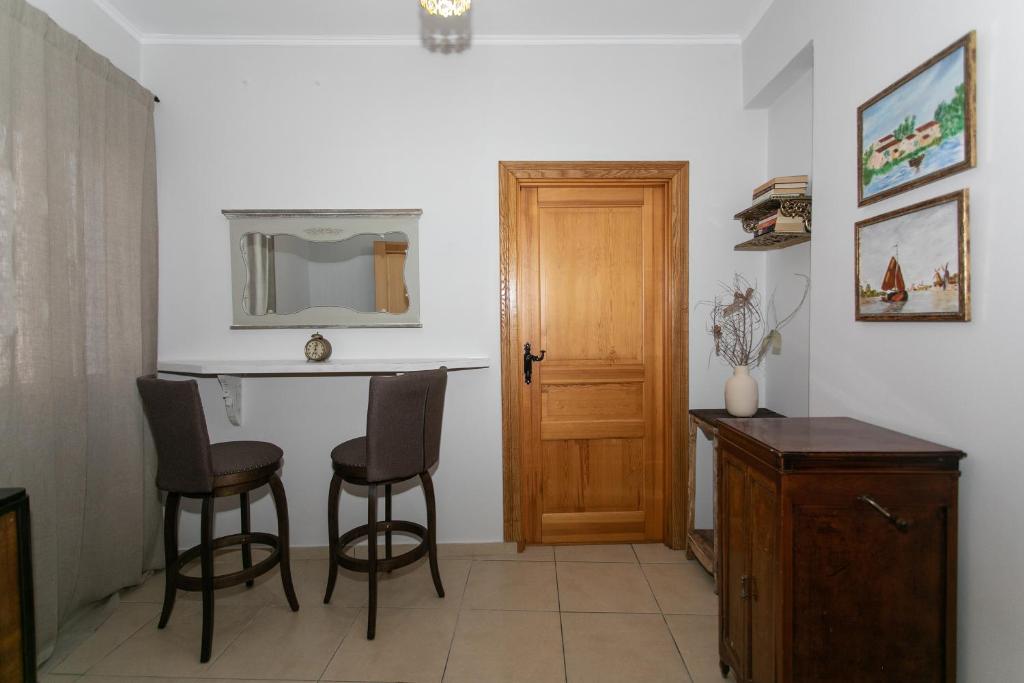 a room with a table and chairs and a mirror at The Old Town hall in Parga