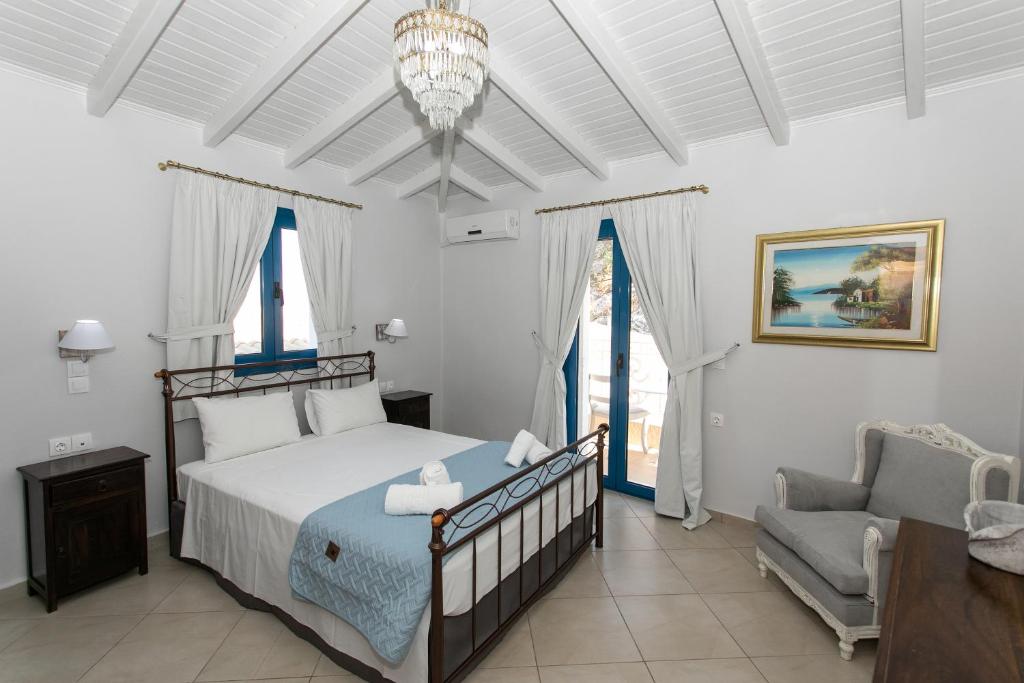 a bedroom with a bed and a chair and a chandelier at The Old Town hall in Parga