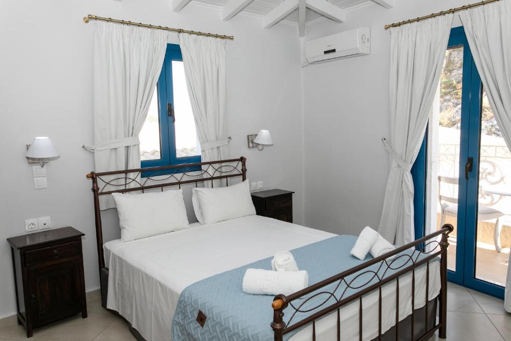 a bedroom with a large bed with blue accents at The Old Town hall in Parga