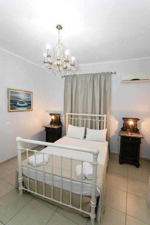 a bedroom with a bed and a chandelier at The Old Town hall in Parga