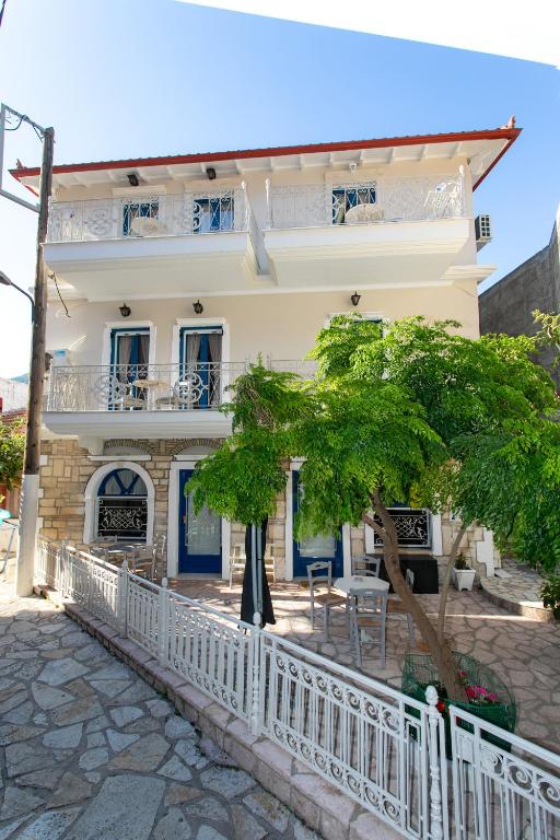 a white fence in front of a house at The Old Town hall in Parga