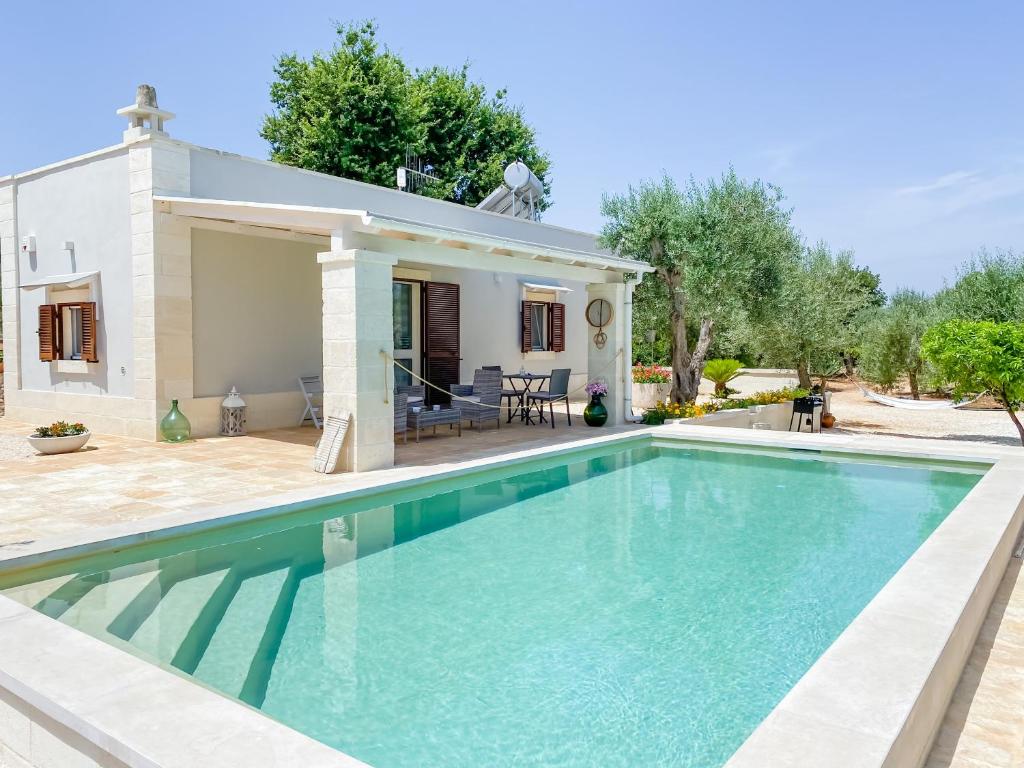a villa with a swimming pool in front of a house at La Mignola in Fasano