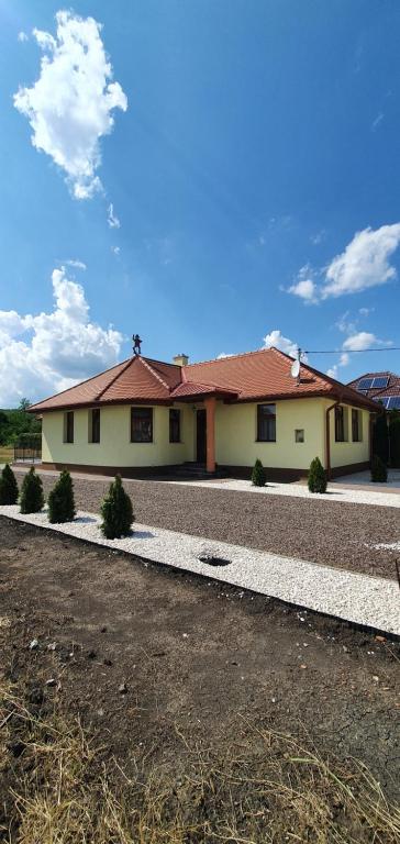 a house with a gravel driveway in front of it at Elringat-lak Apartmanház in Demjén