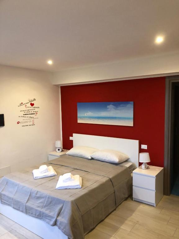 a bedroom with a large bed with a red wall at mammaCristina in Patti