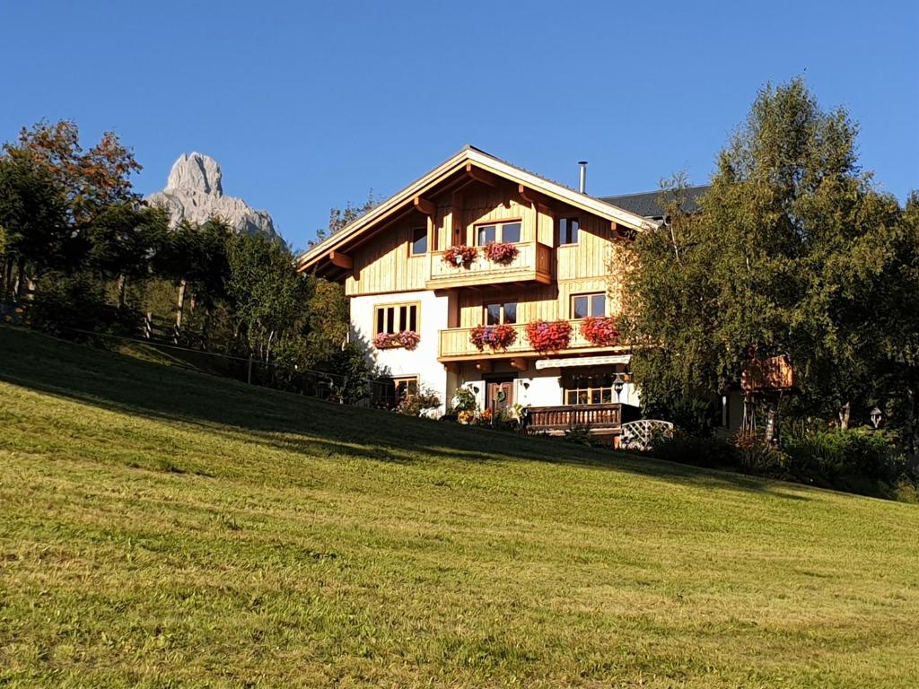 a house on a hill with a green field at Haus Berghoamat in Filzmoos