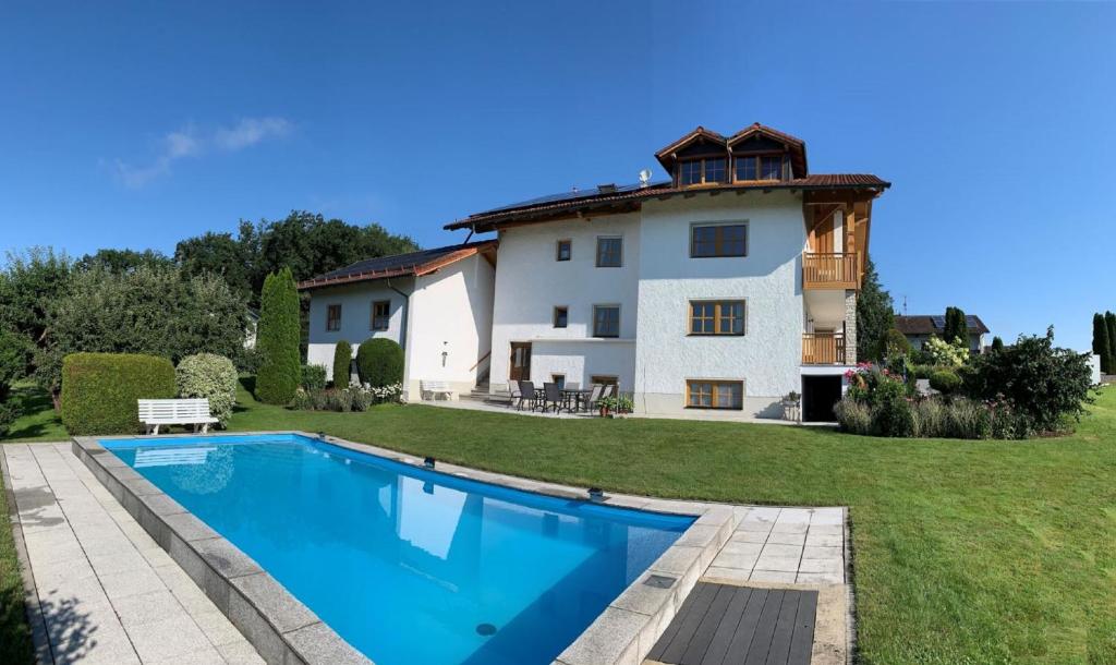 a large house with a swimming pool in front of it at Ferienwohnungen Martina in Windorf