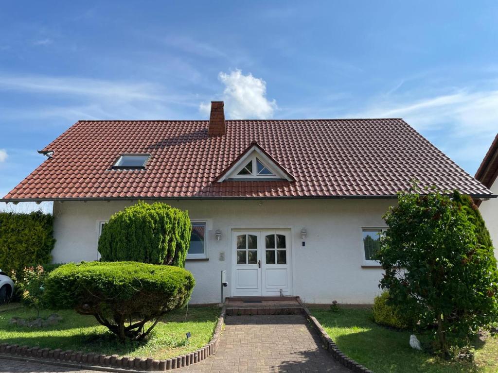 une maison blanche avec un toit rouge dans l'établissement Ferienwohnung Nova, à Tholey